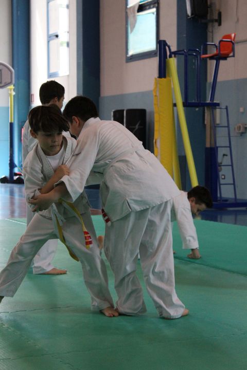 Ragazzi praticano un esercizio a coppie sul tatami